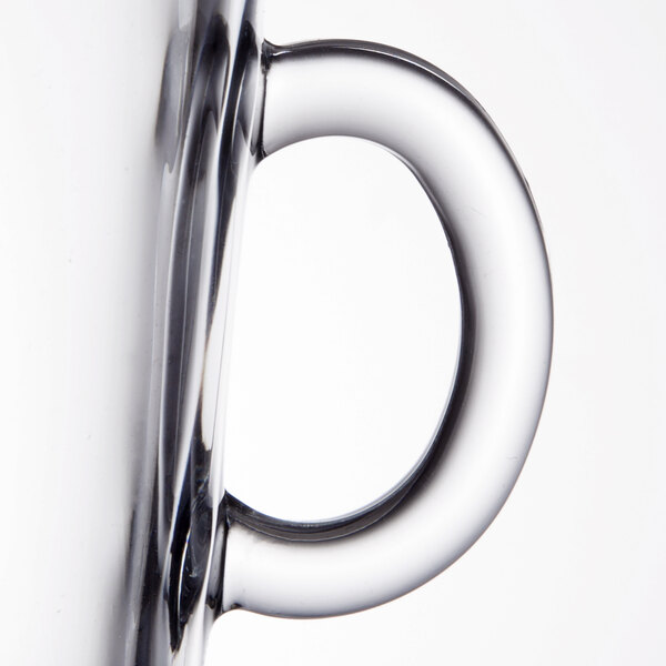 A close-up of the handle of a clear glass coffee mug.