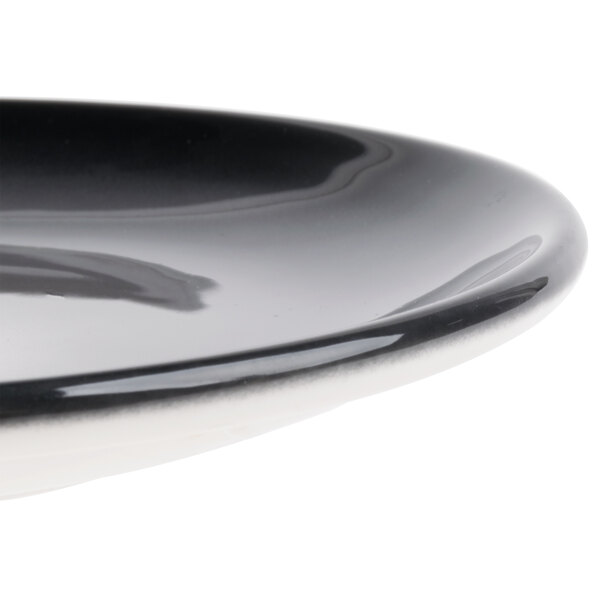 A close-up of a black and white porcelain coupe plate.