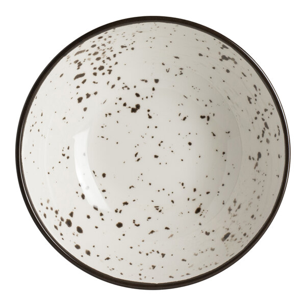 A white melamine round coupe bowl with black speckled pattern and a dark rim.