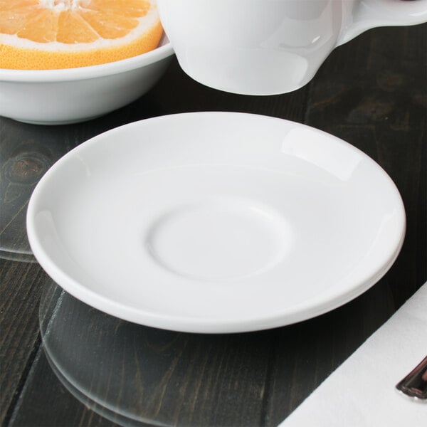 A white porcelain tea saucer with a slightly raised center, designed for holding a teacup.