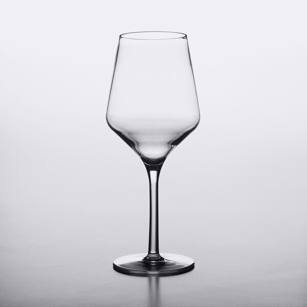 A clear, 16 oz. plastic wine glass with a modern, angular bowl and a long stem.