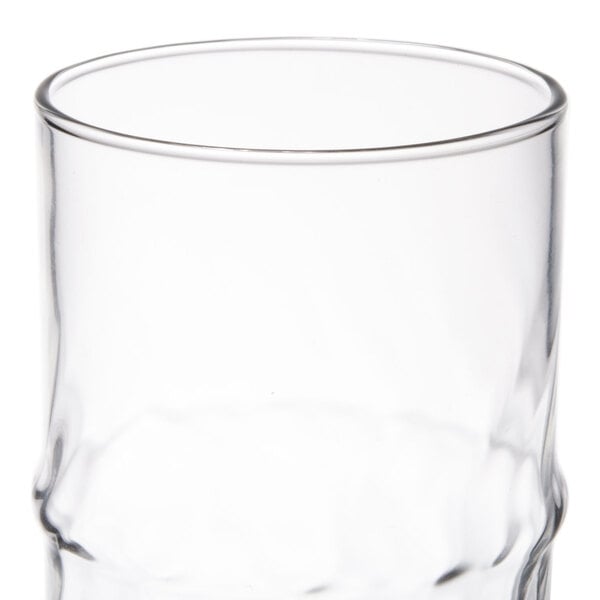 A clear 16 oz. specialty cooler glass with a slightly contoured shape.