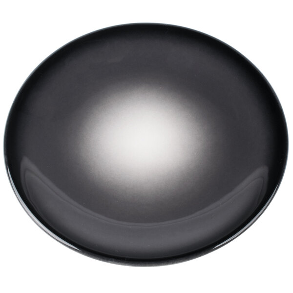 A round, black porcelain coupe plate with a gradient obsidian finish.