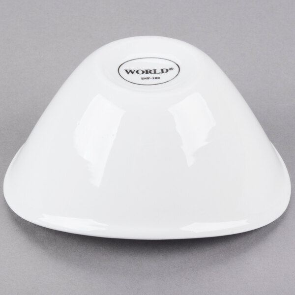 A small, bright white oval porcelain bowl turned upside down.