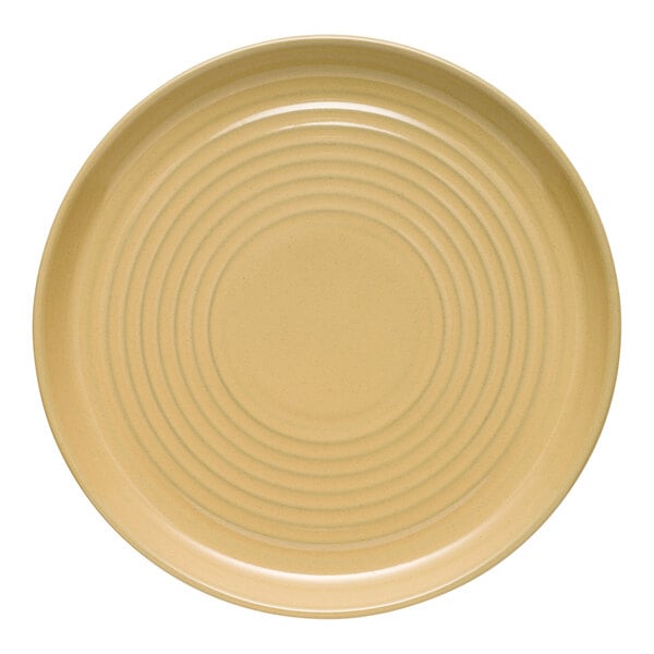 A tan terracotta plate with a circular, ridged design.