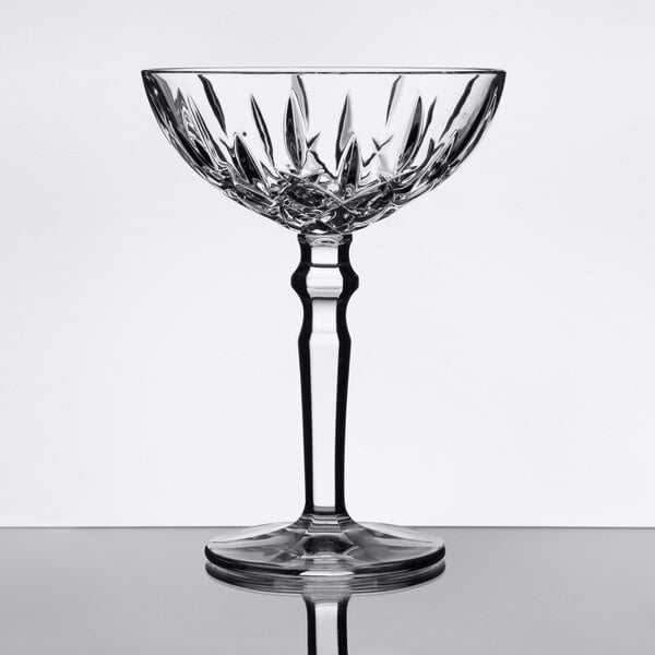 A clear, faceted cocktail glass with a decorative stem and a wide bowl.