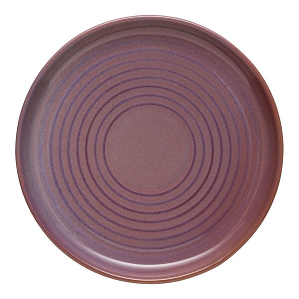 A round mauve terracotta plate with concentric circular patterns.