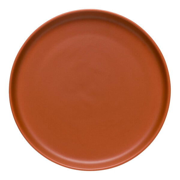 A round, clay-colored satin matte porcelain flat coupe plate.