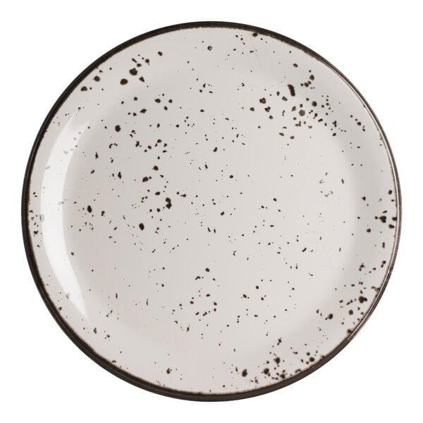 A round white coupe plate with black speckled pattern and a dark rim.