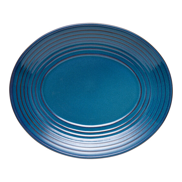 A blue oval terracotta platter with concentric circular ridges.
