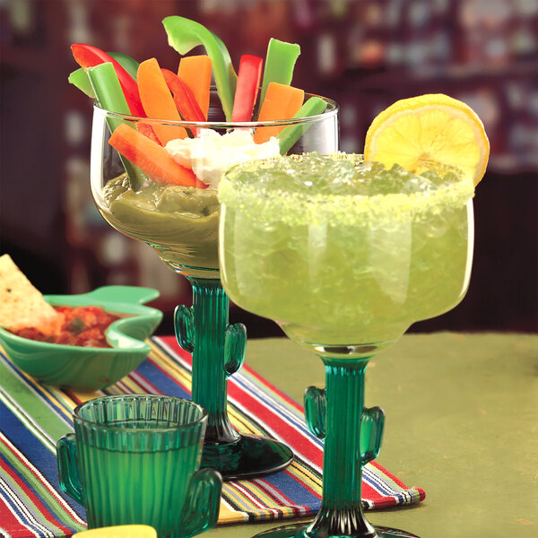 A 12 oz. margarita glass with a green cactus-shaped stem, shown filled with a margarita and garnished with a lemon slice.
