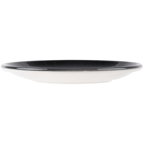 A round porcelain coupe plate with a black interior and white exterior.