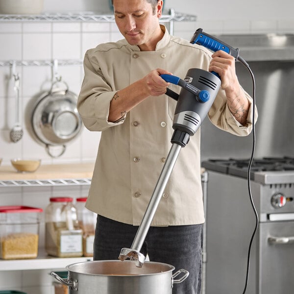 A chef using a Waring WSB65XST Big Stik EvolutionX 18-inch stainless steel blending shaft in a commercial kitchen.