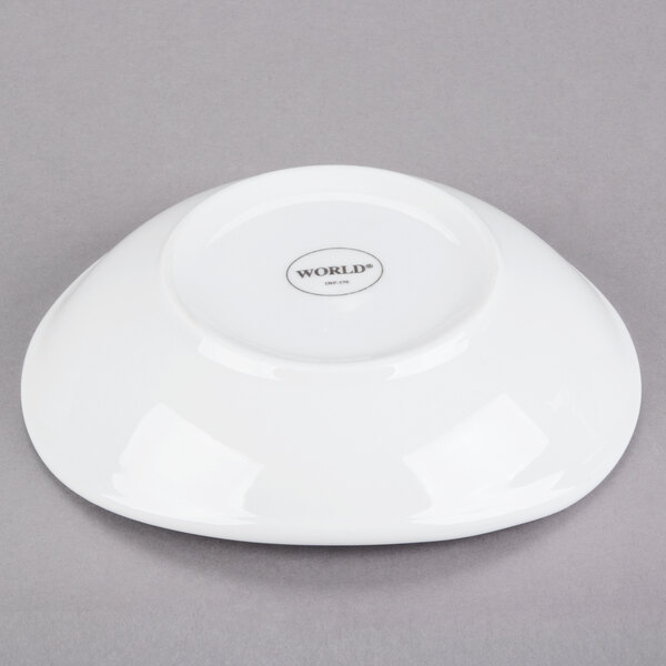 A white oval porcelain bowl shown upside down on a gray surface.