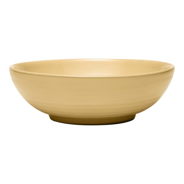 A tan terracotta salad bowl with a simple, round design.