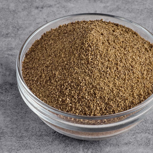 A glass bowl filled with light brown organic coconut sugar granules.