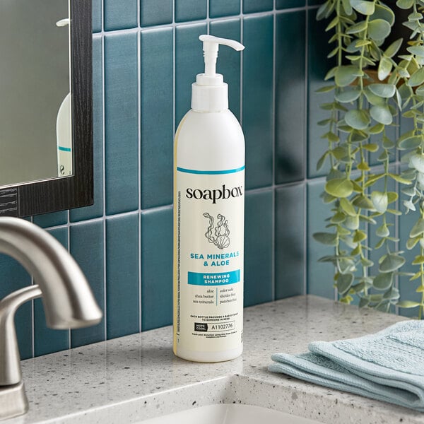 A bottle of Soapbox Sea Minerals and Aloe Renewing Shampoo with a pump dispenser on a bathroom counter.