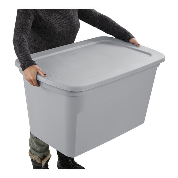 A large gray plastic storage tote with a lid being held by a person.