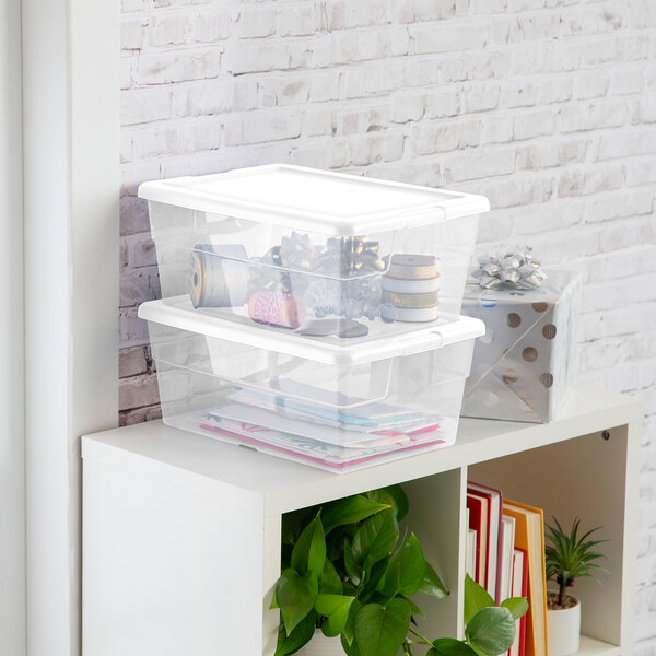 A clear plastic storage tote with a white lid, shown stacked and used for organizing items.