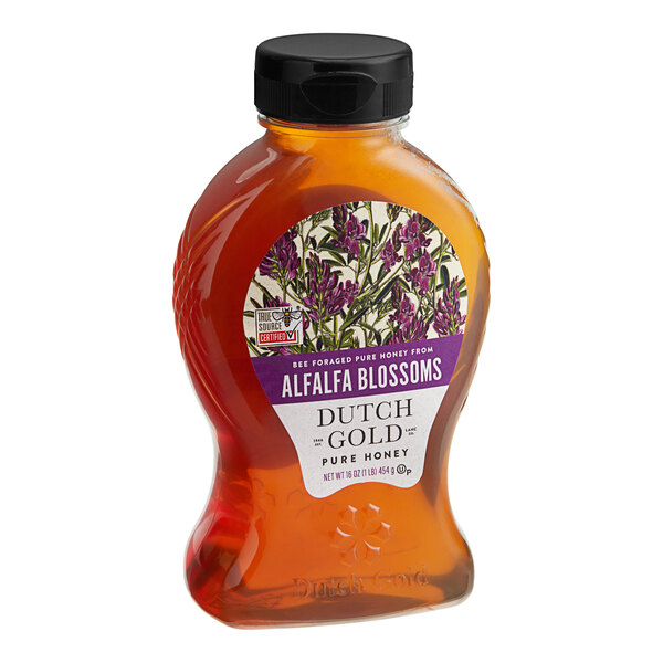 A bottle of Dutch Gold Alfalfa Honey on a table with a label.