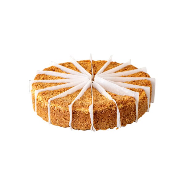 A pre-cut round ricotta cheesecake with individual slices separated by paper dividers.