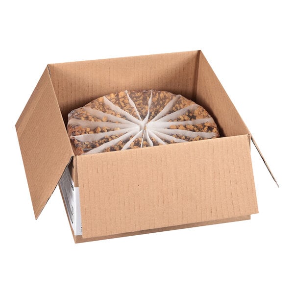 A pre-cut chocolate chip cannoli ricotta cheesecake in a cardboard shipping box.