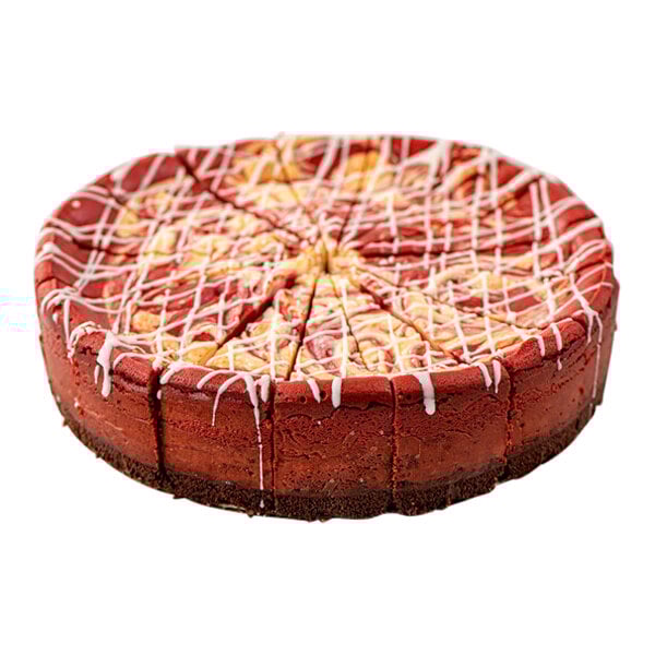 A pre-cut red velvet ricotta cheesecake with a chocolate crust and white icing drizzle.