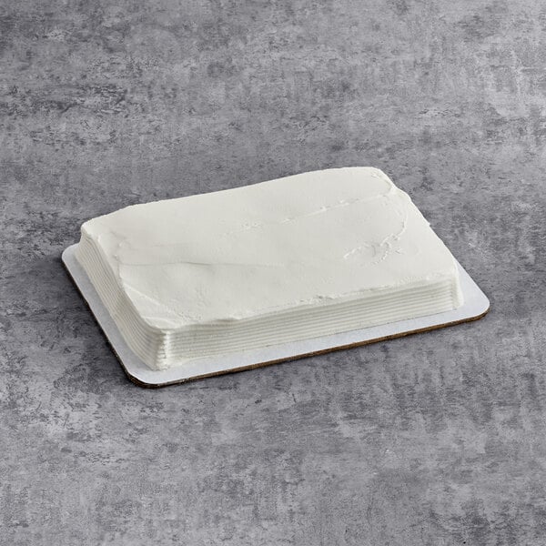 A rectangular chocolate cake with smooth white buttercreme icing on a cake board.