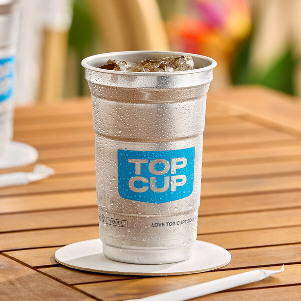 A 9 oz. aluminum cup with a blue 'Top Cup' logo, filled with ice and placed on a wooden table.