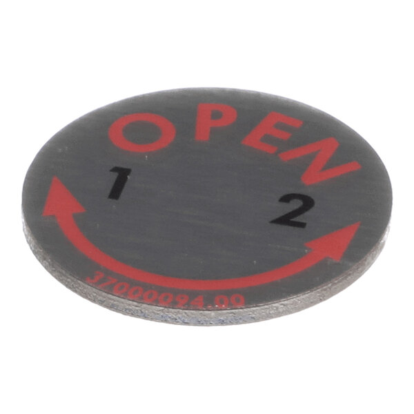 A round steel-look cap for a door handle with 'OPEN' and directional markings printed on it.