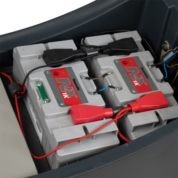 A pair of NX1K lithium-ion batteries installed in a NaceCare Solutions CRL 2128/100T ride-on floor scrubber.