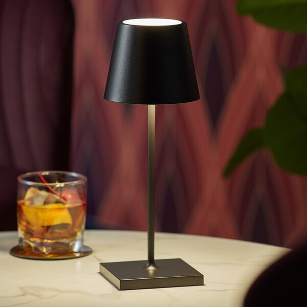 A small black cordless rechargeable table lamp with a square base and conical shade.