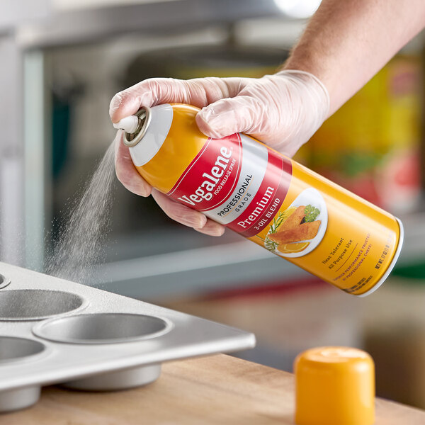 A can of Vegalene all purpose release spray being used to coat a muffin pan.