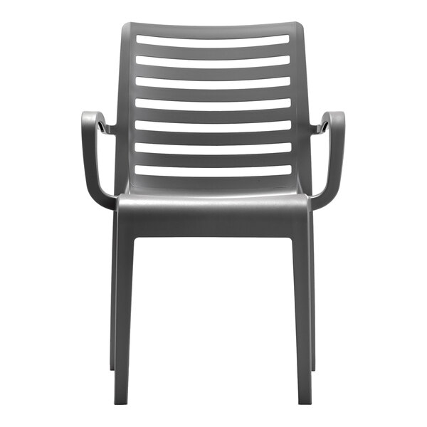 A charcoal-colored resin stackable outdoor arm chair with a slatted back design.