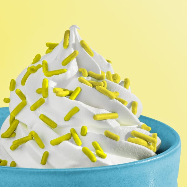 A bowl of soft serve ice cream topped with natural lime green sprinkles.