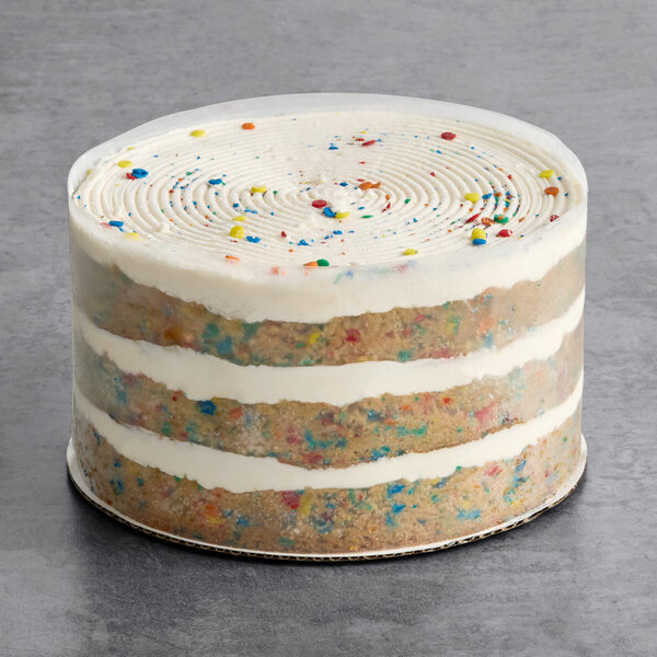 A round vegan funfetti naked cake with visible layers of cake and white frosting, topped with colorful sprinkles.