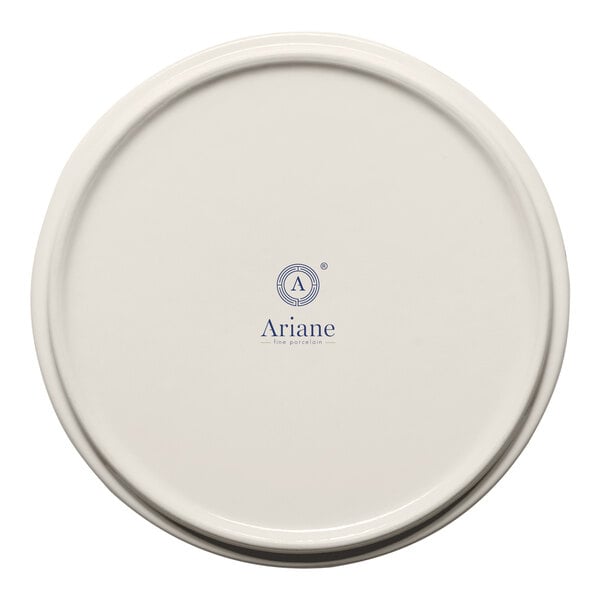 A round cream porcelain plate with a raised rim and Ariane branding on the bottom.