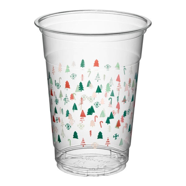 A clear 16 oz. plastic cold cup decorated with a modern holiday pattern featuring small trees, snowflakes, and candy canes.