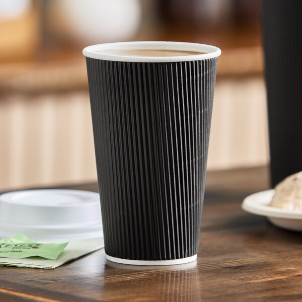 A black 16 oz. double wall ripple paper hot cup.