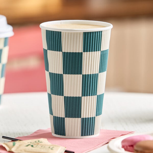 A 16 oz. double wall ripple paper hot cup with a navy checkered pattern.