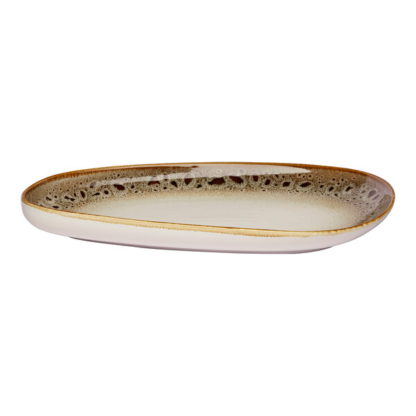 An asymmetrical oval porcelain platter with a brown and cream spotted rim and a raised edge.