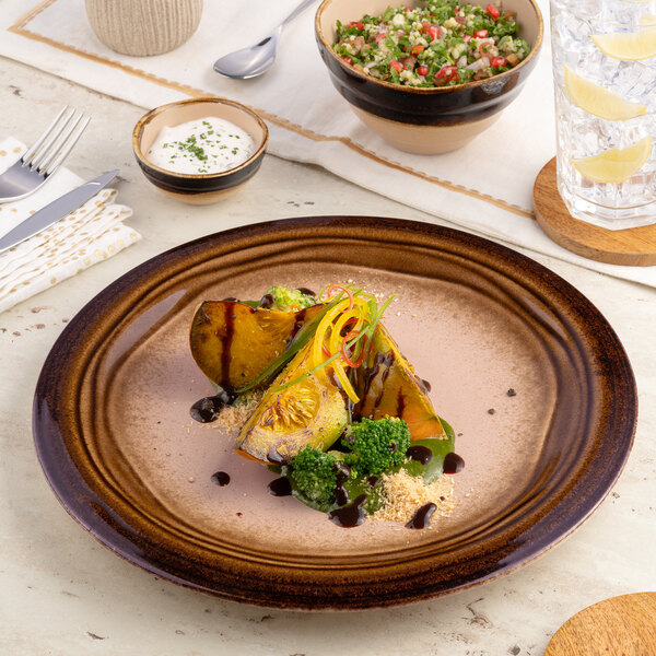 A brown round wide rim porcelain flat plate with a subtle gradient design.