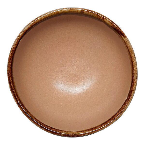 A small brown round porcelain ramekin with an irregular edge.