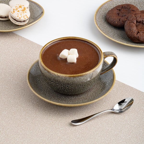 A brown porcelain cappuccino cup filled with hot chocolate and topped with marshmallows, placed on a matching saucer.