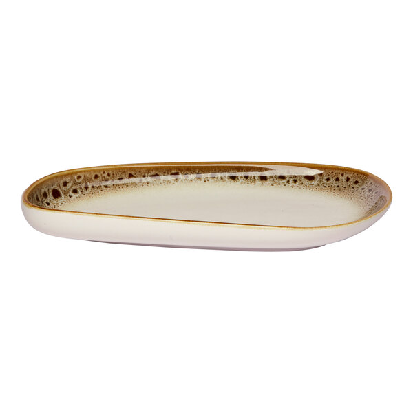 An asymmetrical oval porcelain platter with a brown and cream spotted rim.