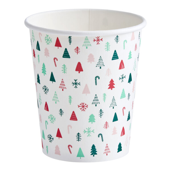 A white paper hot cup with a modern Christmas print featuring trees, snowflakes, and candy canes.