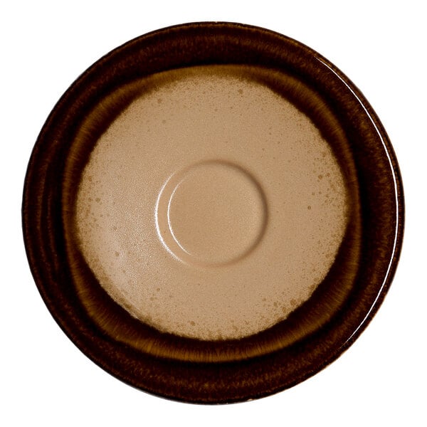 A round brown porcelain saucer with an embossed design and a coupe shape.