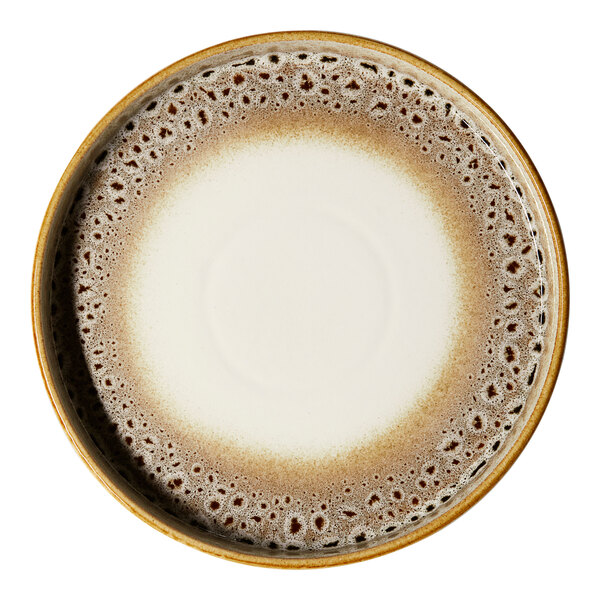 A round porcelain plate with a cream center and a brown, spotted rim.