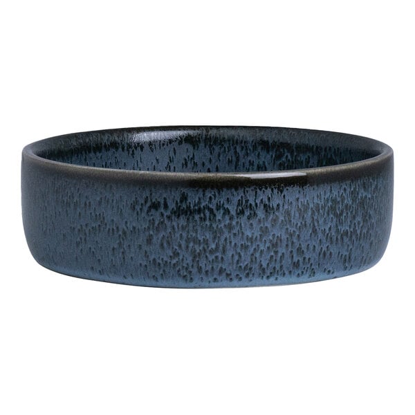 A round, deep porcelain tray with a blue and black speckled finish.