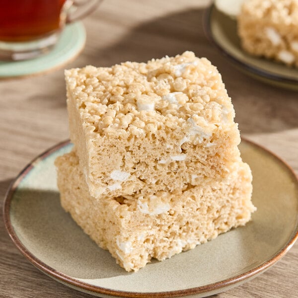 A plate with two stacked chewy marshmallow bars made from puffed rice cereal.